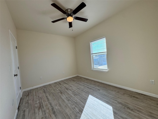 empty room with baseboards, wood finished floors, and a ceiling fan