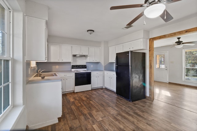 kitchen featuring visible vents, freestanding refrigerator, a sink, light countertops, and range with electric stovetop