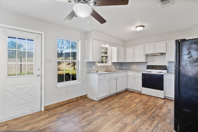 kitchen featuring visible vents, light wood-style flooring, range with electric stovetop, and freestanding refrigerator