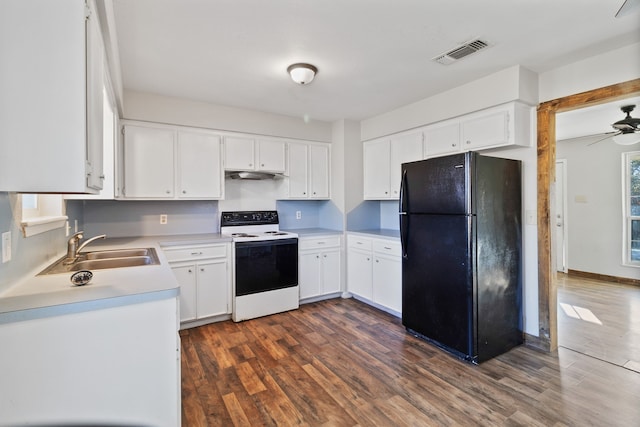 kitchen featuring visible vents, a sink, dark wood finished floors, electric range oven, and freestanding refrigerator