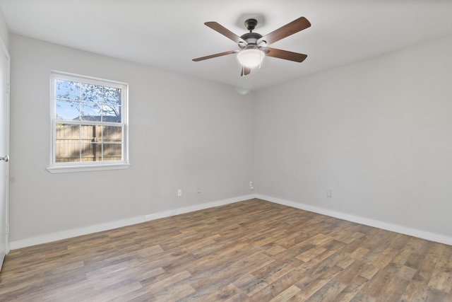 unfurnished room featuring a ceiling fan, baseboards, and wood finished floors