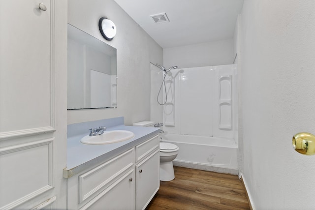 bathroom featuring vanity, wood finished floors, visible vents, tub / shower combination, and toilet