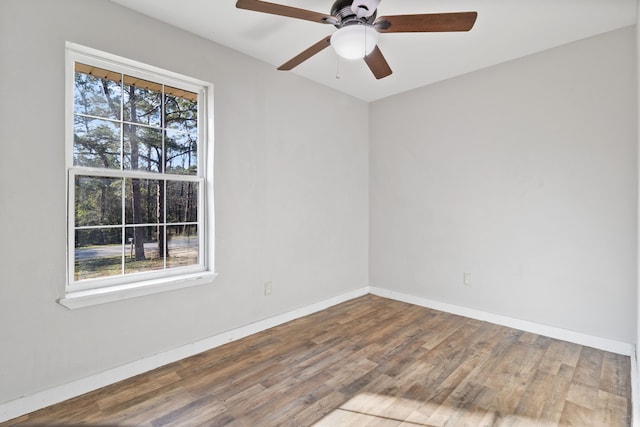 spare room with ceiling fan, baseboards, a healthy amount of sunlight, and wood finished floors