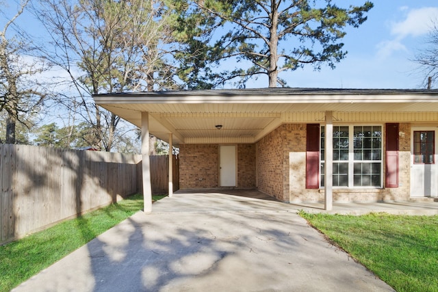 view of parking / parking lot with a carport, driveway, and fence