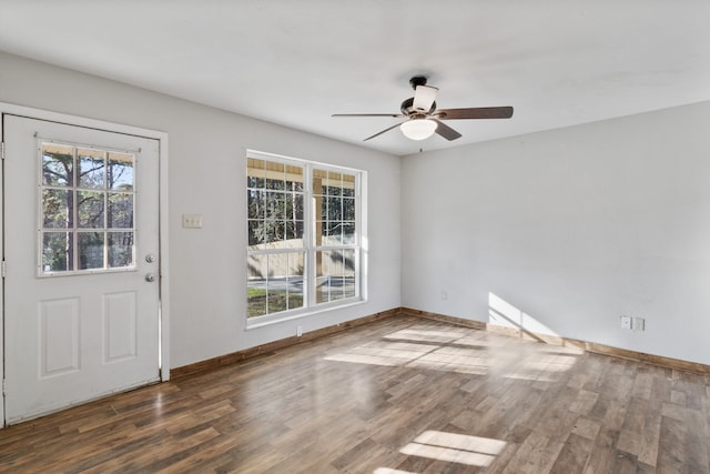 foyer featuring baseboards, wood finished floors, and a ceiling fan