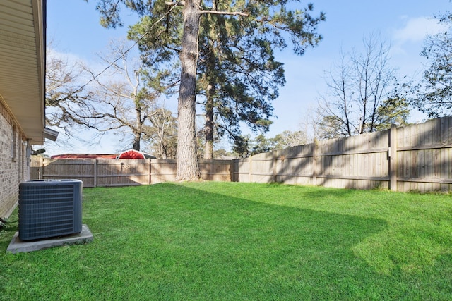 view of yard featuring a fenced backyard and central AC