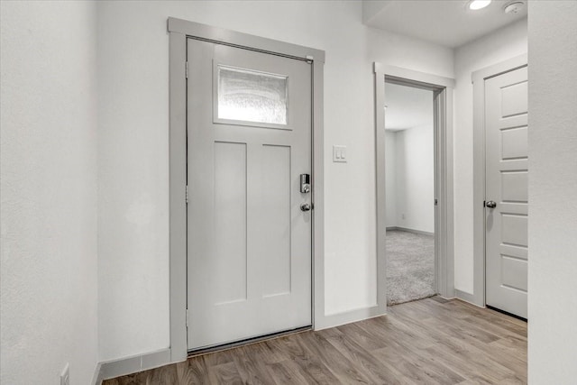 entryway featuring baseboards and light wood finished floors