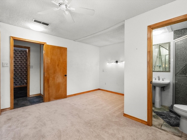 interior space featuring visible vents, a sink, a textured ceiling, and carpet floors