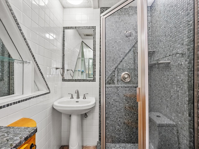 full bathroom with visible vents, a shower stall, and tile walls