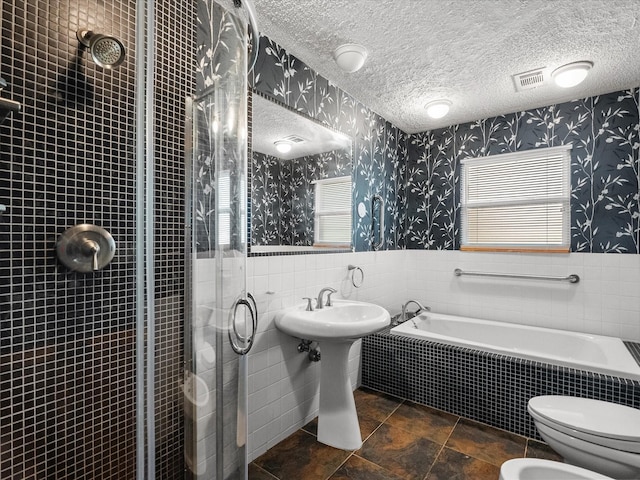 bathroom with wallpapered walls, visible vents, a wainscoted wall, and a textured ceiling