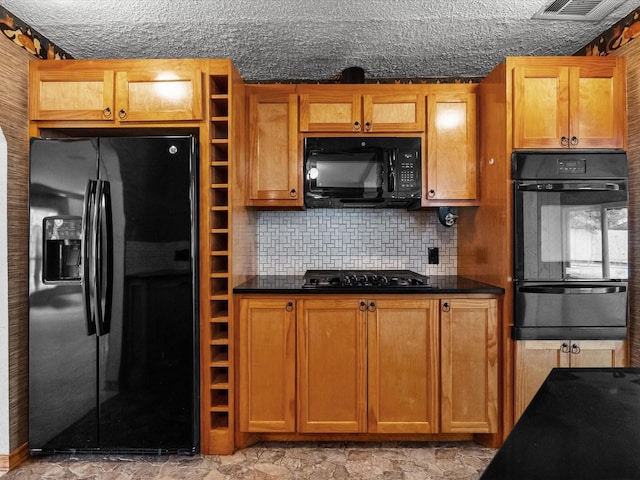 kitchen with dark countertops, visible vents, black appliances, and a warming drawer