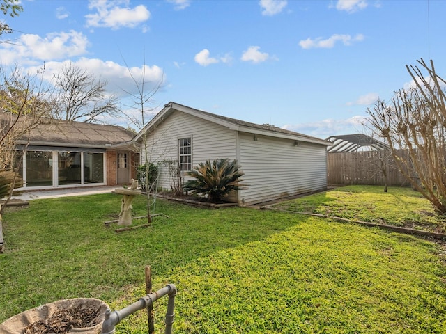 rear view of property with a yard and fence