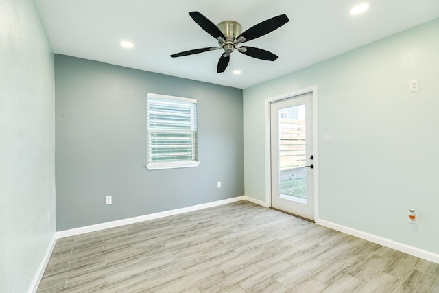 spare room featuring recessed lighting, wood finished floors, baseboards, and a wealth of natural light