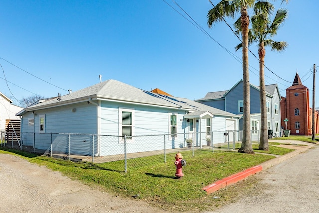 view of front of home featuring a front yard, fence, and roof with shingles