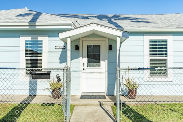 property entrance featuring a shingled roof and fence