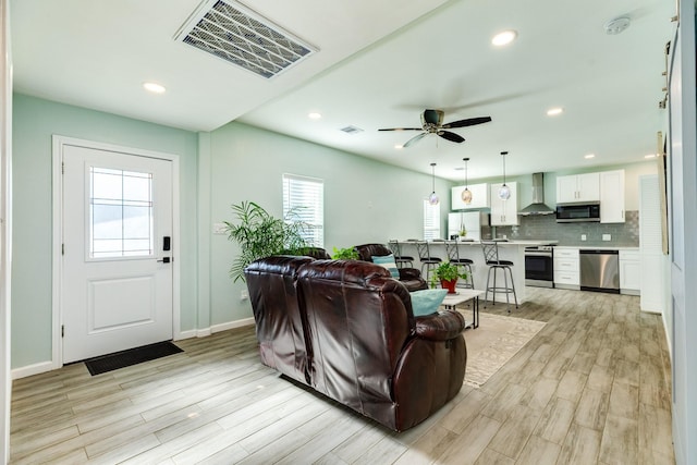 living room featuring visible vents, recessed lighting, and light wood-type flooring