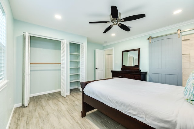 bedroom with recessed lighting, baseboards, a barn door, and wood finished floors