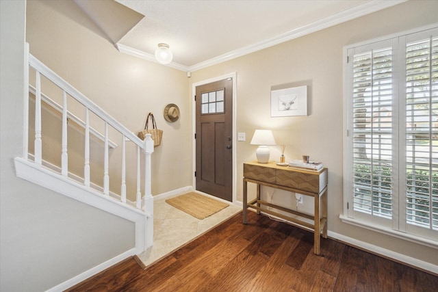 entryway with a wealth of natural light, wood finished floors, stairs, and ornamental molding