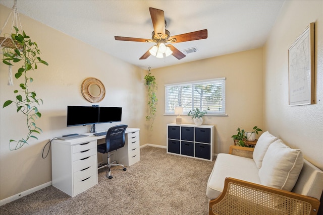 carpeted home office featuring visible vents, baseboards, and ceiling fan