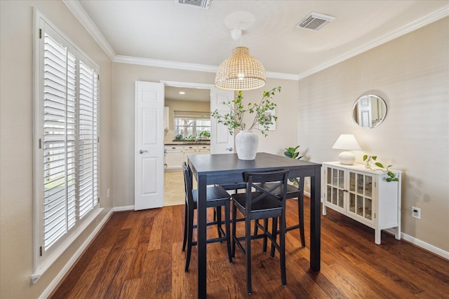 dining space featuring visible vents, baseboards, dark wood-style flooring, and crown molding