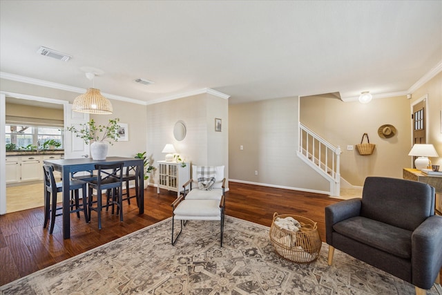 living room featuring visible vents, wood finished floors, stairs, and ornamental molding