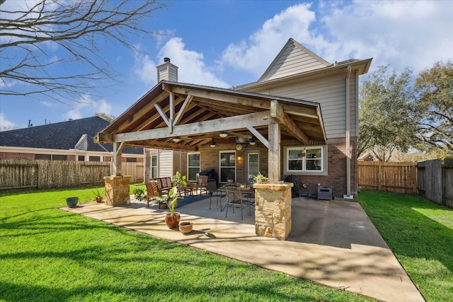 back of property featuring a yard, a fenced backyard, a chimney, ceiling fan, and brick siding