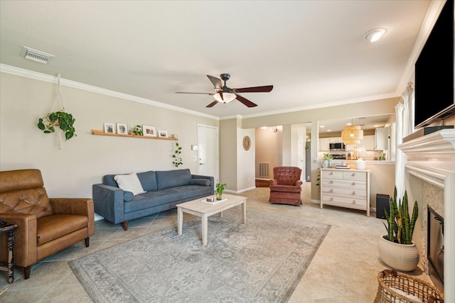 living area featuring a glass covered fireplace, visible vents, and ornamental molding