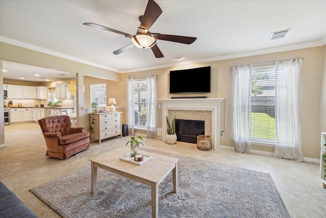 living room featuring light tile patterned floors, baseboards, visible vents, a fireplace with flush hearth, and crown molding