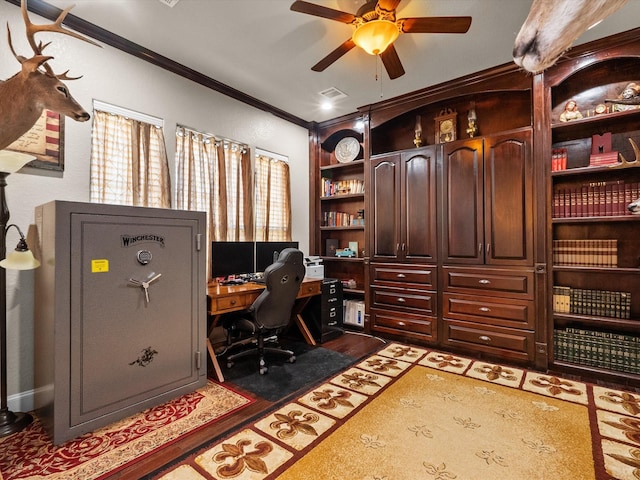 office space featuring wood finished floors, built in shelves, ceiling fan, ornamental molding, and visible vents