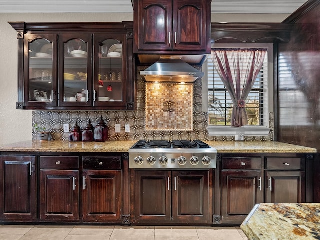 kitchen featuring dark brown cabinets, light stone countertops, stainless steel gas cooktop, decorative backsplash, and wall chimney exhaust hood