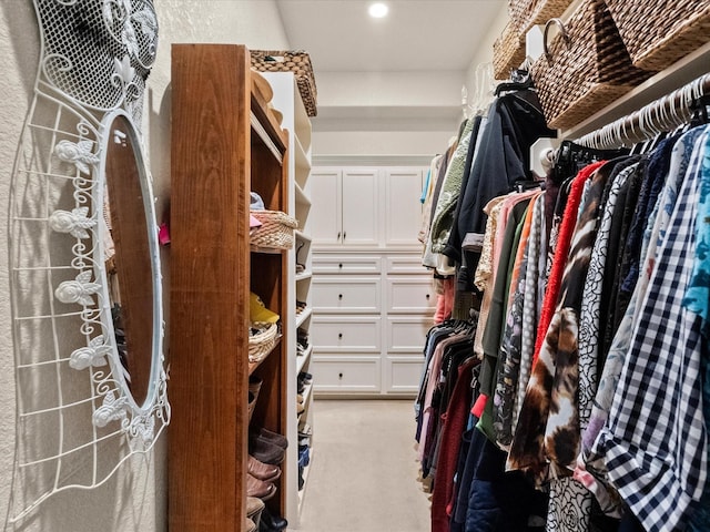 walk in closet featuring light colored carpet