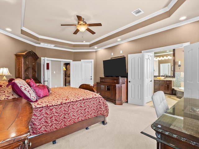 bedroom featuring light carpet, crown molding, a tray ceiling, and visible vents