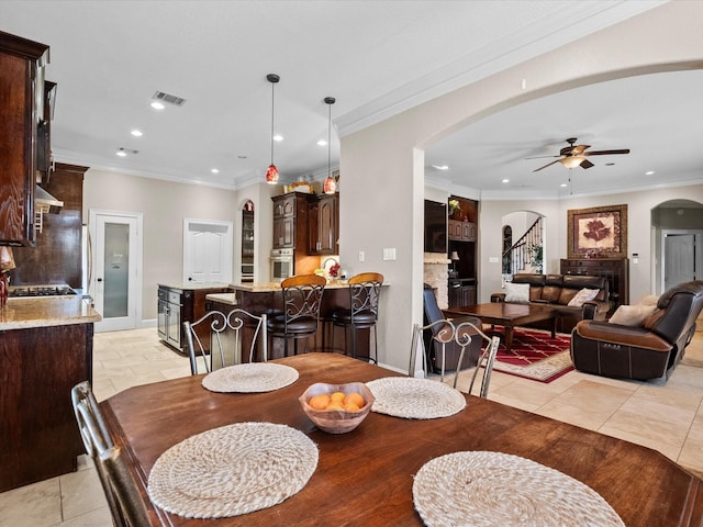 dining room with arched walkways, visible vents, recessed lighting, a ceiling fan, and crown molding