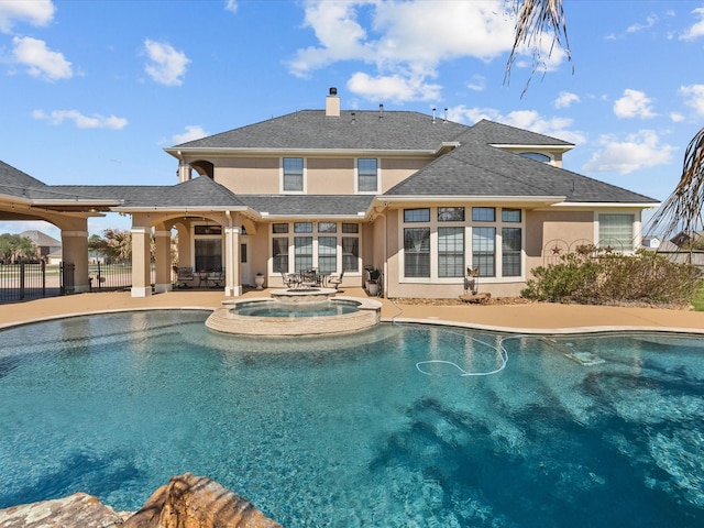 view of pool featuring a pool with connected hot tub, a patio, and fence