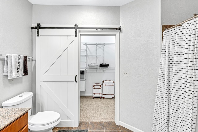 bathroom featuring a shower with curtain, toilet, vanity, and a textured wall