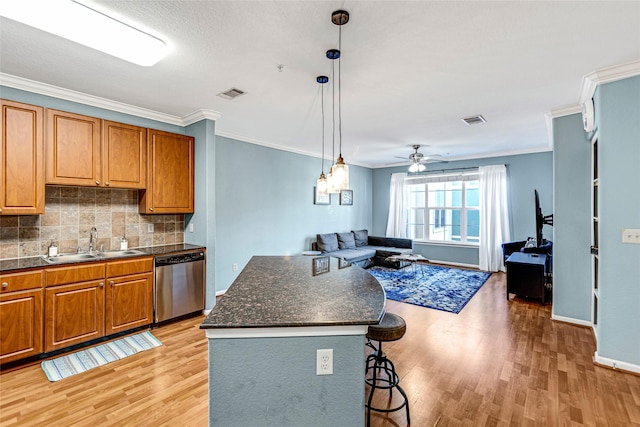 kitchen with stainless steel dishwasher, brown cabinetry, visible vents, and a sink