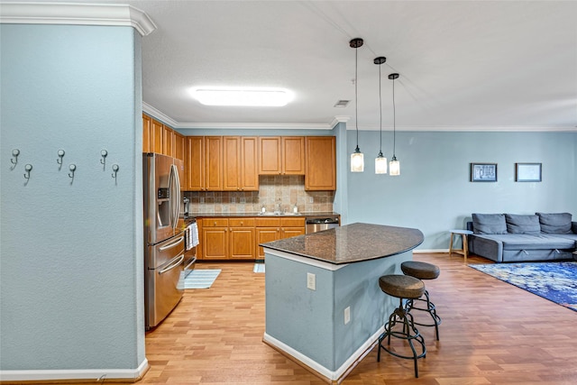 kitchen featuring a kitchen island, light wood-style flooring, stainless steel appliances, crown molding, and tasteful backsplash