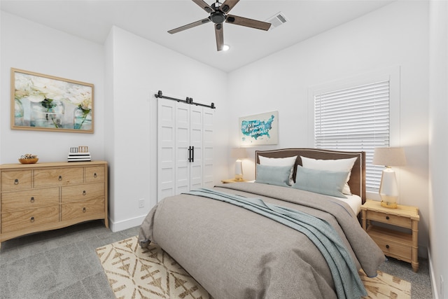 bedroom with carpet, visible vents, baseboards, a closet, and a barn door