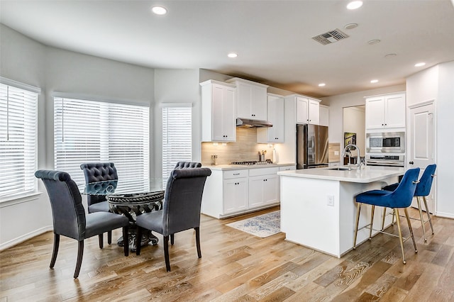 30715 Parkside Passage Dr, Fulshear, TX 77441 - kitchen featuring appliances with stainless steel finishes, under cabinet range hood, a sink, healthy amount of natural light, and recessed lighting