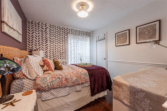 bedroom with a textured ceiling and dark wood-style flooring