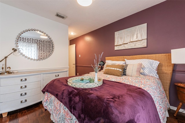 bedroom with visible vents and dark wood-style flooring