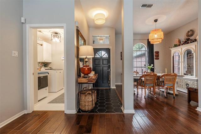 entryway featuring washer and dryer, baseboards, visible vents, and wood-type flooring