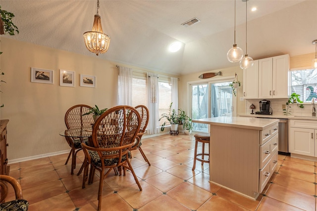 kitchen with a sink, vaulted ceiling, light countertops, white cabinetry, and backsplash