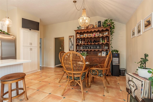 dining space with light tile patterned floors, a chandelier, and vaulted ceiling