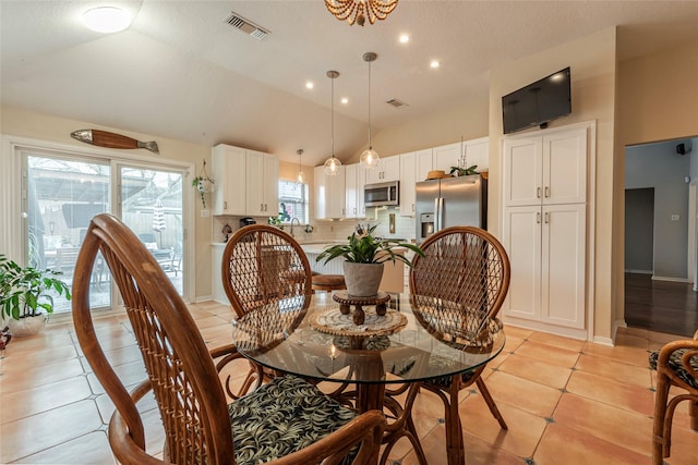 dining space featuring light tile patterned flooring, visible vents, baseboards, and vaulted ceiling