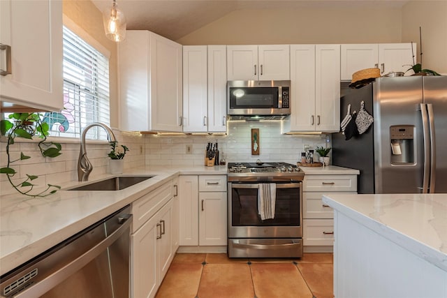 kitchen featuring light tile patterned floors, a sink, white cabinets, appliances with stainless steel finishes, and tasteful backsplash