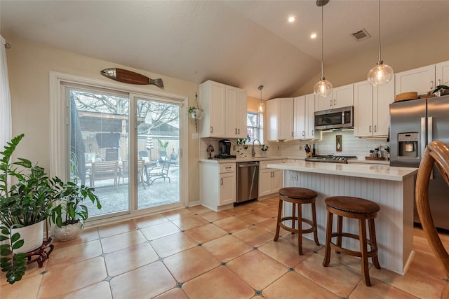 kitchen with visible vents, stainless steel appliances, white cabinets, light countertops, and decorative backsplash