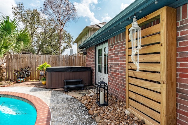 view of pool with a fenced in pool, fence, a hot tub, french doors, and a patio area