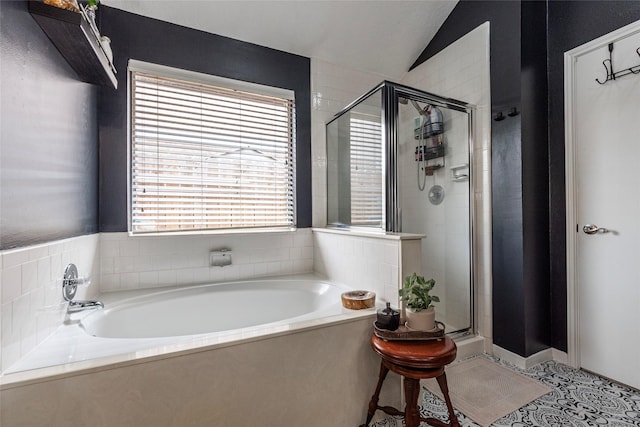 full bathroom featuring tile patterned flooring, a shower stall, a garden tub, and vaulted ceiling