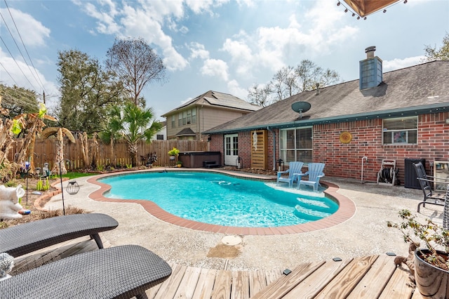 view of swimming pool featuring a patio area, a fenced backyard, a fenced in pool, and a hot tub